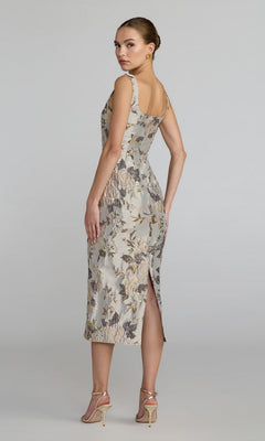 Woman standing in a three-quarter pose wears the Floral Midi Wedding Guest Dress: Mac Duggal 69152—a light-colored, floral midi dress featuring a back slit—paired with strappy high-heeled sandals against a plain background. Perfect for weddings or special occasions, this elegant look channels the timeless charm of the Mac Duggal 69152 style.