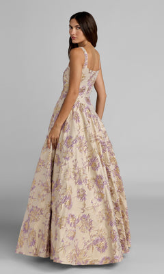 A woman wearing the Long Formal Dress: Mac Duggal 69163, featuring a sleeveless design, full ballgown skirt, and delicate floral-print pattern, looks over her shoulder against a plain gray background.