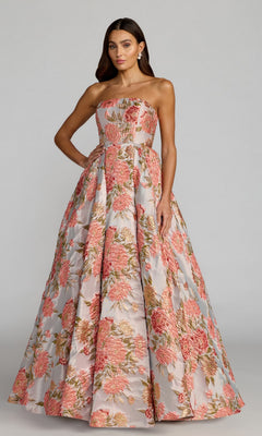 A woman wearing the Mac Duggal 69169 long formal dress in Pastel Multi, a strapless, floor-length A-line gown featuring a pink, green, and gold floral brocade pattern, stands against a plain background.