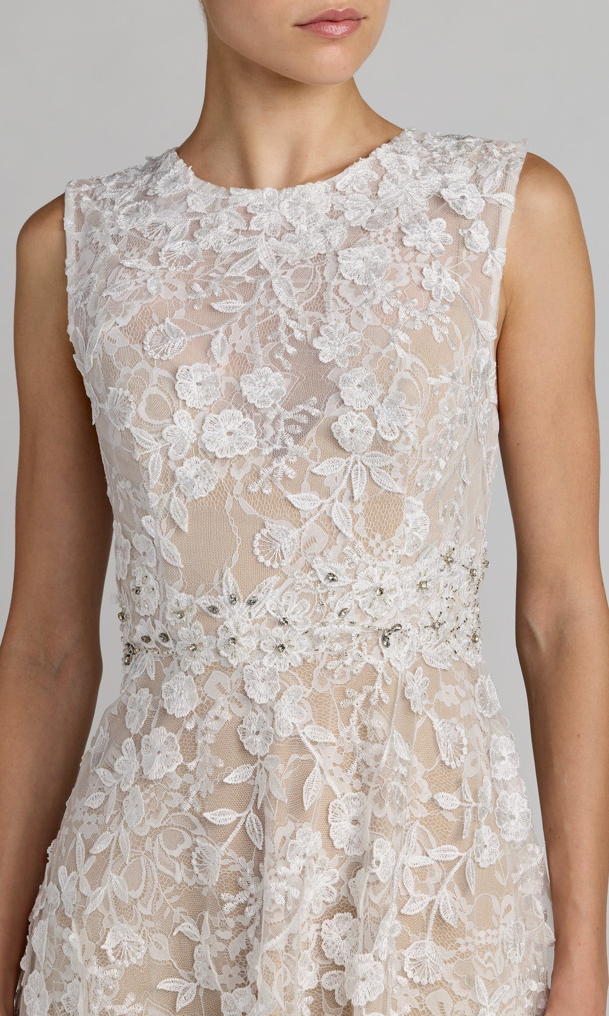 A woman wearing the Mac Duggal 69192 Tea-Length Party Dress, featuring a sleeveless fitted bodice with floral lace and beaded embellishments, and a beautifully tailored waist, shown from shoulders to hips.