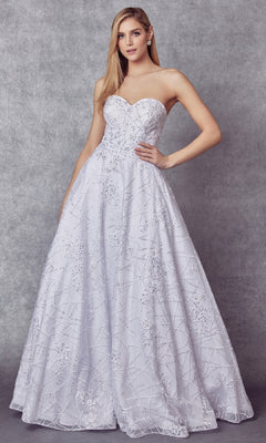 A woman in the Juliet 692 long prom dress, featuring a strapless sweetheart neckline and sequin-detailed fitted bodice, stands against a gray textured background.