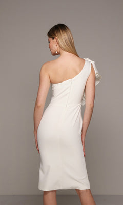 A woman stands facing away against a plain background, modeling the Alyce 70005 knee-length semi-formal dress—a white, one-shoulder design with ruffle detail.