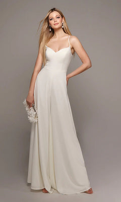 A woman poses elegantly against a plain gray background, wearing the Long White Jumpsuit: Alyce 70022 with wide-leg pants and holding a small bag.