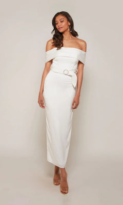 Woman wearing the Alyce 70041 tea length formal dress, featuring off-the-shoulder style with belt and buckle detail—ideal as a chic wedding guest outfit against a plain light background.