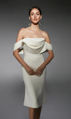 Woman wearing the Alyce 70055 knee-length semi-formal dress in ivory, featuring off-the-shoulder draped sleeves, styled as a chic sheath, standing against a plain gray background.