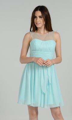 A woman models the Sheer-Neck Short Wedding-Guest Party Dress 7006, a light blue sleeveless dress with a sheer neckline, standing against a plain gray background.