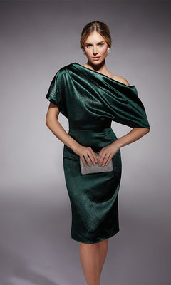 Woman wearing the Alyce 70060 knee length semi-formal dress in forest green, holding a silver clutch against a plain gray background.