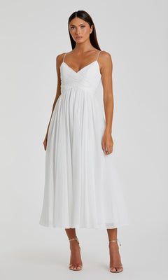 A woman models the Mac Duggal 70099 A-Line Midi Wedding Guest Dress—sleeveless, white, and semi-formal with spaghetti straps—perfect for tea-length occasions. She stands against a plain background in strappy high-heeled sandals.