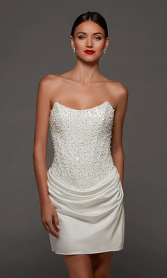 A woman wearing the Alyce 70105 short white party dress in diamond white, featuring a strapless corset bodice and draped satin skirt, styled with crystal earrings and red lipstick.