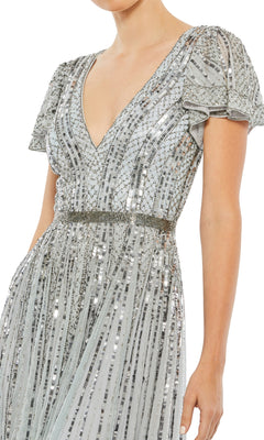 Woman wearing the Long Formal Dress 70108 by Mac Duggal, a silver short-sleeve sequin A-line dress with a V-neckline, vertical bead embellishments, and a fitted waistband.