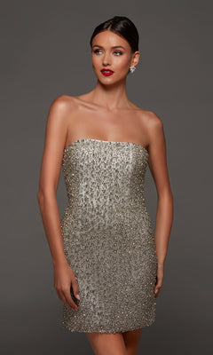 A woman wearing the Alyce 70124 short white party dress in diamond white, featuring a strapless beaded design with a fitted silhouette, adorned with shimmering sequins, stands against a plain gray background.