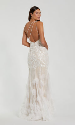 A woman wears the Long Formal Dress 70131 by Mac Duggal—an ivory mermaid gown with thin straps, floral details, and a sheer layered skirt—standing against a plain background.