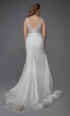 A woman faces away, wearing the Alyce 7016 long white dress featuring a sleeveless design, sheer lace back with button details, and a sweeping train set against a plain gray background.