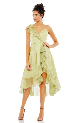 A woman wears the Mac Duggal 70163 short green wedding guest dress with ruffles and thin straps, paired with heeled sandals, against a white background.