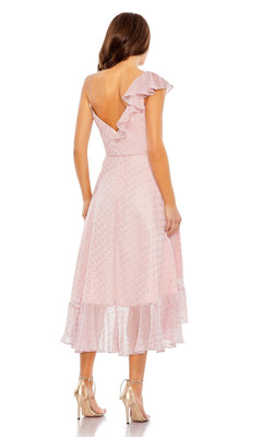 Woman wearing the Mac Duggal 70163 short green wedding guest dress, featuring a one-shoulder ruffled v-neck and low back with sheer polka dot overlay, paired with heeled sandals, standing and facing away.