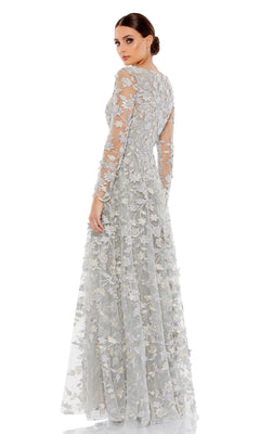 Woman posing in a Mac Duggal 70224 long sleeve formal dress with intricate floral embroidery, light gray color, standing against a plain white background.