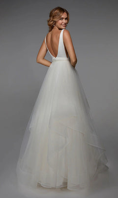 A woman in the Alyce 7022 Long White Dress with a sleeveless top, beaded waistband, and A-line tulle skirt stands facing away, glancing over her shoulder.
