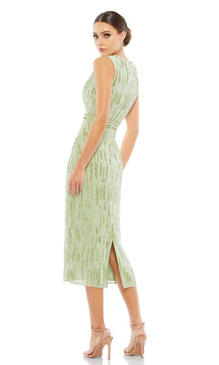 Woman in the Mac Duggal 70264 Beaded Midi Wedding Guest Dress—sleeveless, light green with gold patterns, back slit—stands in nude heels, looking over her shoulder against a white background. Perfect for special occasions.