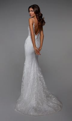 A woman models the Long White Dress: Alyce 7028—a fitted, backless white lace gown with delicate embroidery, thin straps, and a flowing train—against a gray background. Ideal for formal events or wedding inspiration.