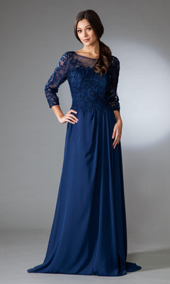 A woman poses against a neutral background in the affordable Modest Long-Sleeve Mother-of-the-Bride Dress 7043—a floor-length navy blue gown with sheer lace sleeves and intricate bodice embroidery.