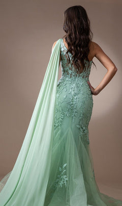 A woman stands facing away, wearing the One-Shoulder Long Lace Mermaid Prom Dress 7048 in mint green, featuring floral lace, a fitted floor-length silhouette, and a long sash draped over one shoulder.