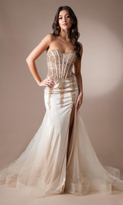 A woman wears the Strapless Long Beaded Sheer-Bodice Prom Dress 7051, featuring a corset-style bodice, gold beading, and a sheer tulle skirt with a high slit, standing against a plain background.
