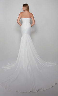 A woman is photographed from the back in a strapless, fitted satin Long White Dress: Alyce 7060 with a trumpet skirt and long train, set against a plain light gray background.