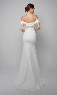 Woman in the Alyce 7062 long formal dress featuring an off-the-shoulder neckline, floor-length fitted silhouette, 3D floral back accents, and hair styled in a low bun.