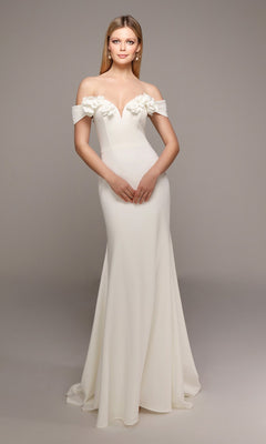 A woman poses against a neutral background in the Alyce 7062 long formal dress—an off-the-shoulder, fitted white gown with 3D floral accents on the neckline.