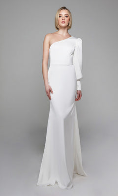 Woman in the Alyce 7065 Long White Dress, featuring an ivory fitted silhouette with a single long sleeve and one-shoulder design, standing against a plain light gray background.