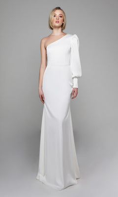 A woman wears the Alyce 7065 Long White Dress, a fitted one-shoulder evening gown with an asymmetrical sleeve, set against a plain gray background.