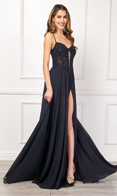 A woman wearing the Long Black Corset Prom Dress by Amelia Couture 7066, featuring a sheer lace bodice with spaghetti straps and a high slit, stands against a white paneled wall.