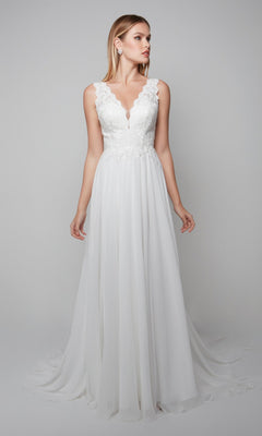 A woman stands against a plain light gray background wearing the Alyce 7071 Long White Dress—a sleeveless lace chiffon gown with a V-neckline and flowing skirt.