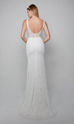 A woman in the Long White Dress: Alyce 7075, a sleeveless white sheath gown with lace appliqués and a long train, stands facing away against a plain gray background.
