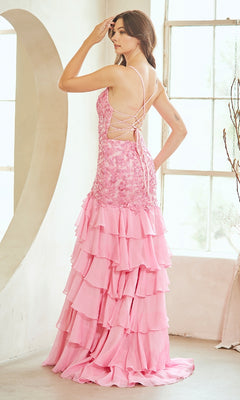 A woman stands indoors facing away from the camera, wearing the Amelia Couture 7085 Ruffled Long Prom Dress in pink with an embroidered bodice, lace-up back, and layered ruffles.