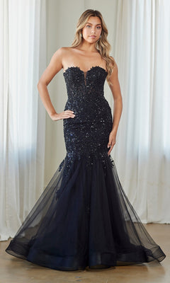 A woman in a black Amelia Couture 7090 Strapless Mermaid Prom Gown with fitted floral lace and sequin details stands indoors before white curtains.