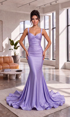 A woman wearing the Atria 7090H long prom dress in lilac, featuring a fitted silhouette and an elegant lace-up back, stands in a modern, sunlit living room with large windows and contemporary furniture.
