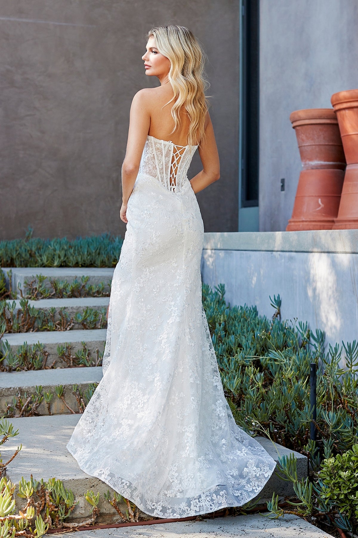 Amelia Couture 7097 strapless white lace floor-length gown with a corset-style lace-up back.