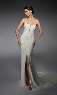 A woman poses in the Alyce 7104 long white dress, featuring thin straps, a deep V neckline, and a high slit, against a gray background.