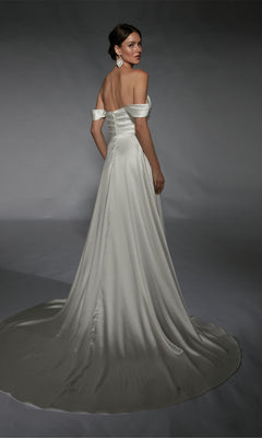 A woman in the Alyce 7107 Long White Dress, featuring a satin A-line silhouette and long train, stands against a plain gray backdrop, looking over her shoulder.
