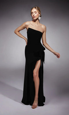 A woman poses in the Alyce 7114 long formal dress—a strapless black evening gown with a thigh-high slit—paired with neutral heels and statement earrings against a plain gray background.