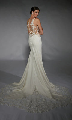 A woman in the Alyce 7117 Long White Dress, featuring an ivory hue, lace back, and elegant train, stands facing away and looks over her shoulder.
