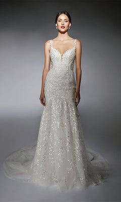 A woman wears the Alyce 7122, a long ivory dress featuring floral lace appliqués, thin straps, and a flowing train.