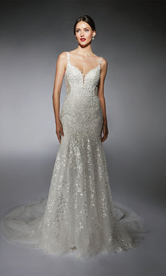 A woman models the Alyce 7122 long white dress, a fitted, sleeveless gown featuring floral lace appliqués and a sweeping train, against a gray background.