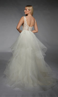 A woman faces away from the camera wearing the Long White Dress: Alyce 7126, an ivory ball gown with a sleeveless layered tulle skirt, sheer lace back, and delicate floral appliqués.