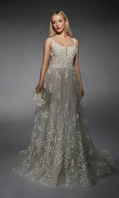 A woman wears the Long White Dress: Alyce 7132 in Ivory/Lt Latte—a sleeveless, floor-length gown with sheer fabric and delicate white floral embroidery—holding a small flower accessory against a dark backdrop.