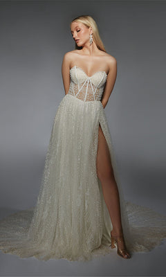 A person wearing the Long Formal Dress: Alyce 7133, which features a strapless design, sheer bodice, high slit, and lace details, stands against a plain gray background.