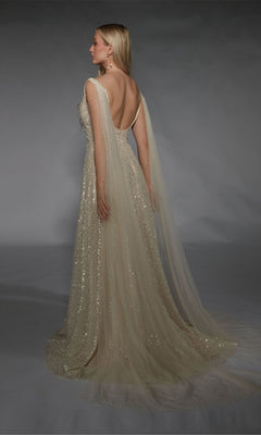 Woman wearing the Alyce 7134 long white dress with sequin embellishments, a deep back, and sheer cape-like panels, posing against a gray background.
