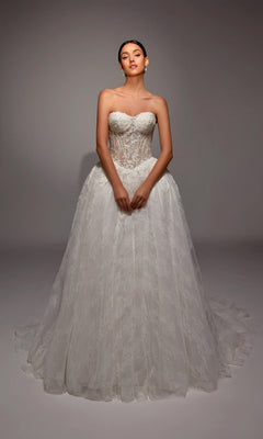 A woman poses gracefully against a plain, neutral background in the Alyce 7163 long white dress, featuring a strapless fitted bodice and full ball gown skirt.