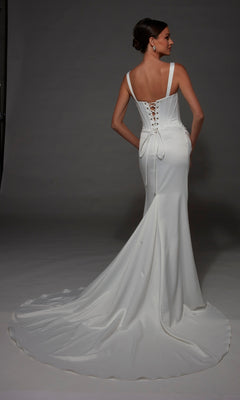 A woman stands facing away against a gray background, wearing the Alyce 7171 Long Wedding Dress—a fitted satin gown featuring a corset bodice, lace-up back, and a long train.